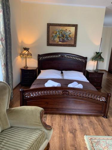 a bedroom with a wooden bed and a chair at Dwór na Wrzosowisku in Cisna