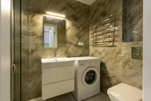 een badkamer met een wasmachine en een wastafel bij VIP Apartment near Center in Lviv