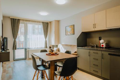 una cucina e una sala da pranzo con tavolo e sedie di Lemy Lux Apartments a Velingrad