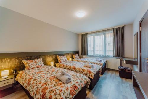 una camera d'albergo con due letti e una televisione di Lemy Lux Apartments a Velingrad