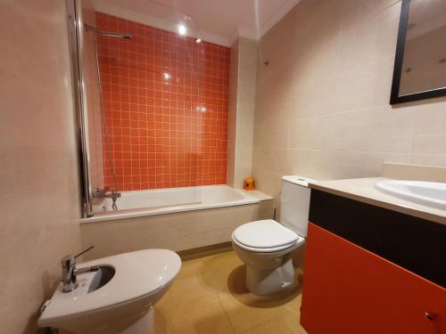 ein Badezimmer mit einem WC, einer Badewanne und einem Waschbecken in der Unterkunft Apartamento con piscina a escasos metros de A Lanzada in Pontevedra