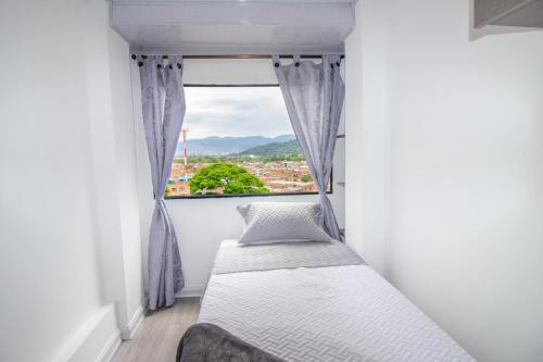 Habitación pequeña con cama y ventana en Excelente apartamento cerca a parques turísticos, en Medellín