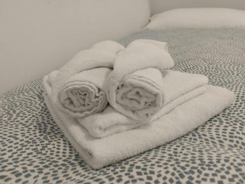a pile of white towels on a bed at Mini Estudio JACUZZI DOBLE SEVILLA "POLIGONO INDUSTRIAL" in Seville