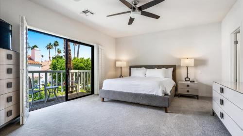 a white bedroom with a bed and a balcony at TV202 Modern 2 Bedroom Tennis Villa at LQ Resort in La Quinta