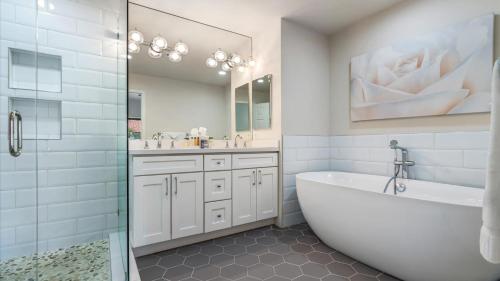 a white bathroom with a tub and a sink at TV202 Modern 2 Bedroom Tennis Villa at LQ Resort in La Quinta