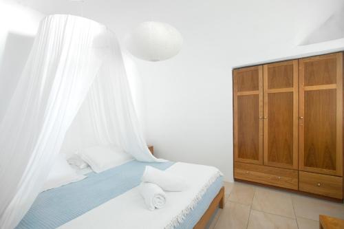 a bedroom with a bed with a white curtain at Gabbiano Traditional Cave Houses in Oia