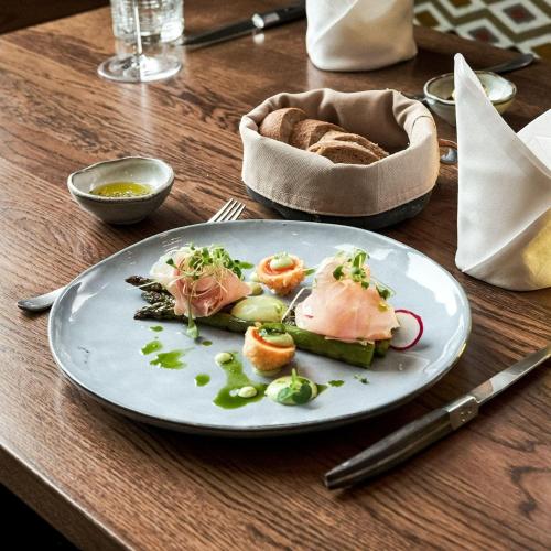 a plate of food on a wooden table at Centurion Swiss Quality Towerhotel Windisch in Brugg