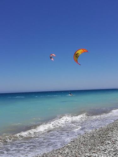 two kites flying over the ocean on a beach at Marilena Mare Seaside & Jacuzzi House 50meters from sea in Ialyssos