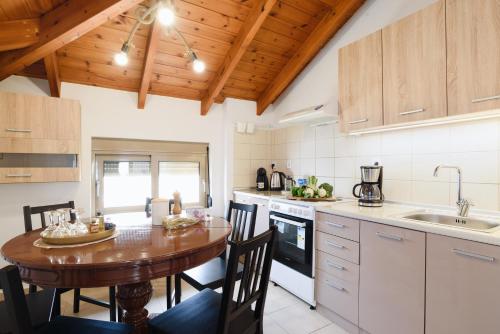 a kitchen with a wooden ceiling and a wooden table at Marilena Mare Seaside & Jacuzzi House 50meters from sea in Ialyssos
