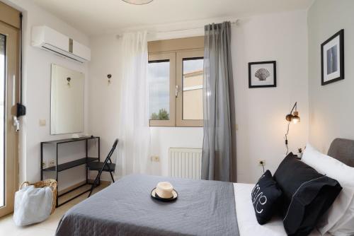 1 dormitorio con 1 cama con sombrero en Marilena Mare Seaside House, en Ialisos