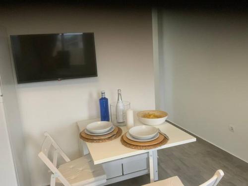 una mesa con platos y una TV en la pared en Es Pujols isla de la Calma en Es Pujols