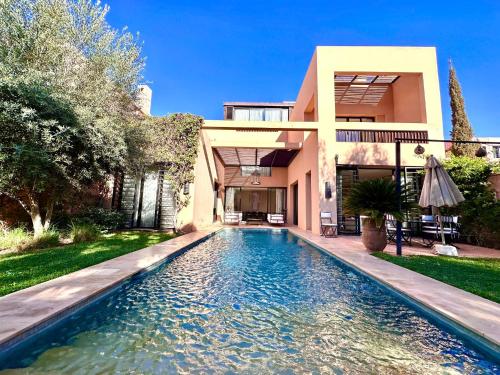 uma casa com piscina em frente a uma casa em Al Maaden Ryad 69 a Marrakesh em Marrakech