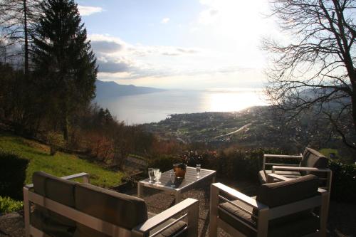 duas cadeiras e uma mesa com vista para o oceano em Elvira House Montreux, un lieu magique ! em Montreux