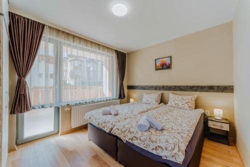 a bedroom with a bed and a large window at Katerina Apartments 2 in Velingrad