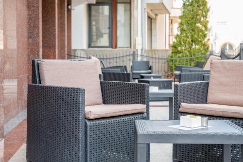 una fila de sillas y mesas de mimbre en un patio en Garni Hotel MB, en Budva