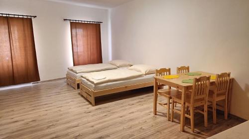 a room with a bed and a table and chairs at Apartmány Javorník in Javorník