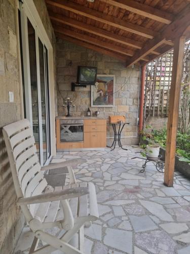 un patio con banco y TV en una pared de piedra en villa Tia Maria en Hisarya