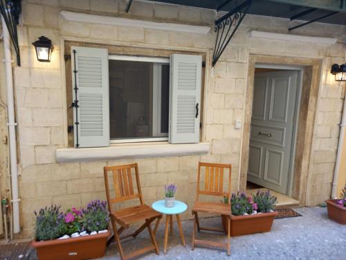 a patio with two chairs and a table and a window at Studio CASINELLA in Corfu