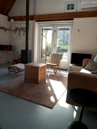 a living room with a couch and a table at TIJ Tiny house aan het getijdewater in Zierikzee in Zierikzee