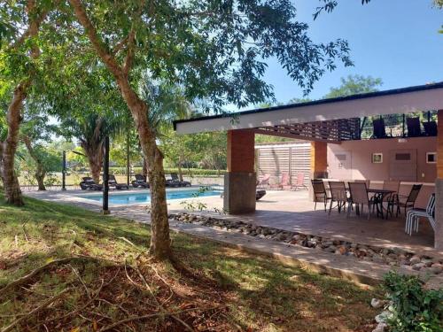 un patio con mesa y sillas junto a una piscina en Condo Playa Hermosa, Puntarenas, en Muñeco