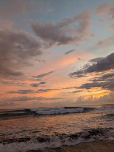 a sunset on the beach with the ocean at Condo Playa Hermosa, Puntarenas in Muñeco
