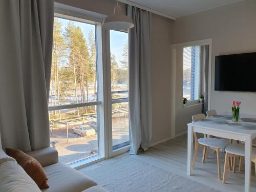 a living room with a table and a large window at Uusi lomahuoneisto Kalajoen Hiekkasärkillä in Kalajoki