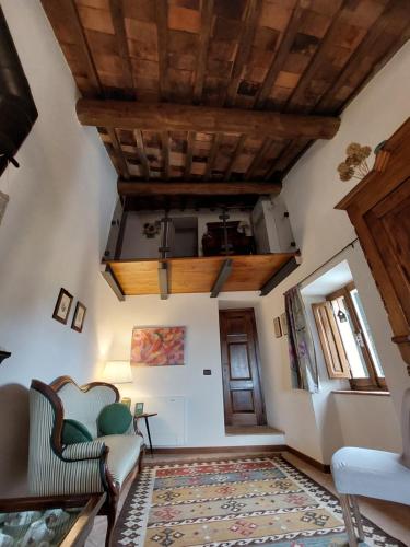 a living room with a ceiling with wooden beams at Casa di Corte in Scansano