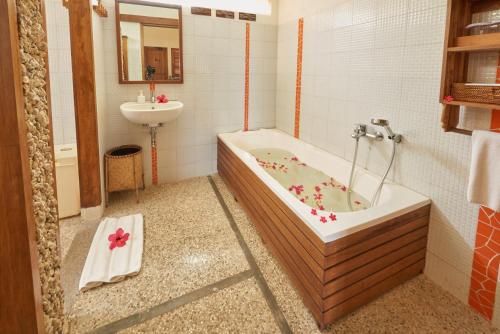 Cocotinos Manado في مانادو: حمام مع حوض استحمام ومغسلة