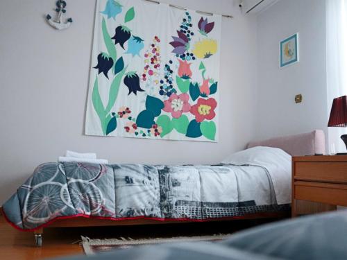 a bedroom with a bed and a painting on the wall at Νatasas Place in Evia in Amarinthos