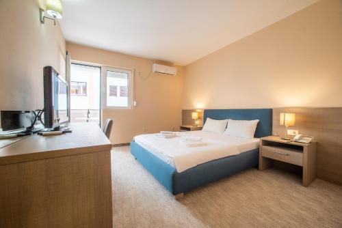 Habitación de hotel con cama y TV en Garni Hotel MB, en Budva