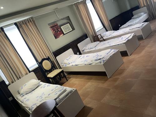 eine Gruppe von 4 Betten in einem Zimmer mit Fenstern in der Unterkunft Mang’o Hostel in Aqtau