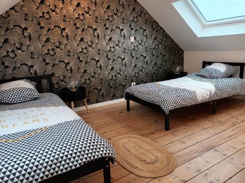 two twin beds in a room with a wall at Maison stACHEUL*gare/centre*wifi in Amiens