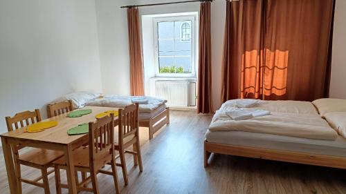 a room with two beds and a table and chairs at Apartmány Javorník in Javorník