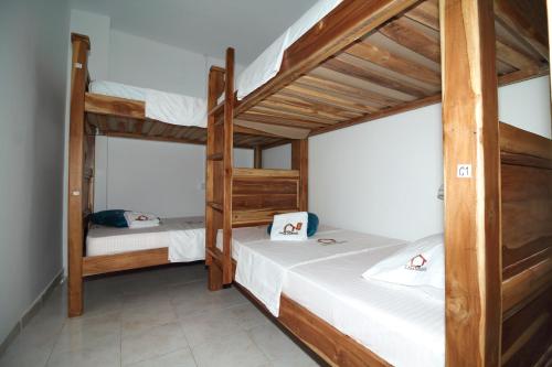 a bedroom with two bunk beds with white sheets at Hostal Casa Torres Centro Historico - Adults Only in Cartagena de Indias