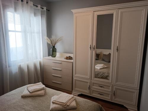 a bedroom with a large white cabinet with a mirror at Betty's Garden House in Nea Anchialos