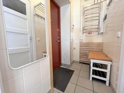 a small bathroom with a door and a bench at Kotedžas nuomai - Retro 70, Šiauliai in Šiauliai