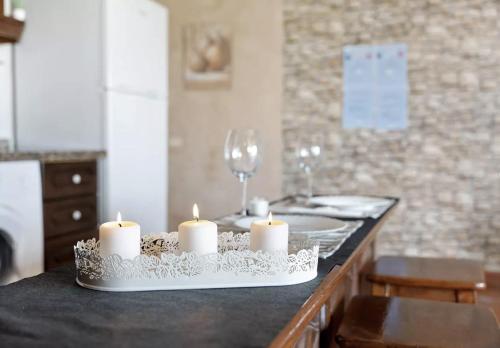 una mesa con velas y copas de vino en un mostrador en Graciosa Sunset Apartment, en Los Silos