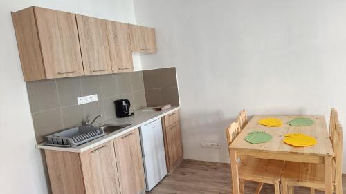 a kitchen with a sink and a table with chairs at Apartmány Javorník in Javorník