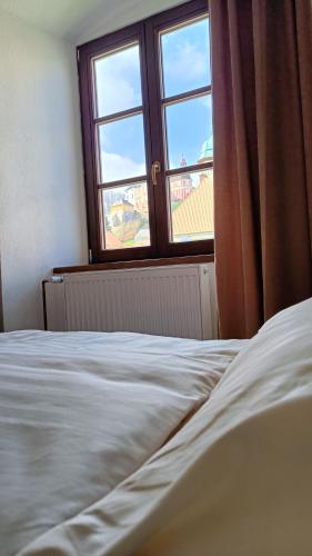 a bedroom with a white bed and a window at Apartmány Javorník in Javorník