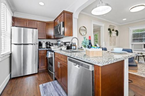 a kitchen with wooden cabinets and a stainless steel refrigerator at Historic Heights Cozy Nook Apartment in Houston