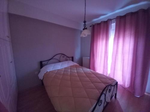 a bedroom with a bed and a window with pink curtains at Tripoli Center in Tripolis