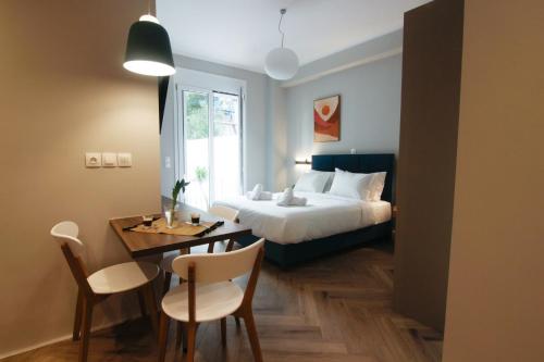 a bedroom with a bed and a table and chairs at Patio Apartment near metro & Acropolis in Athens