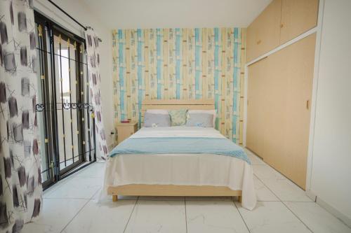 - une chambre avec un lit et une grande fenêtre dans l'établissement Le Palmiste lovely 2-bedroom duplex with pool, à Grand Gaube