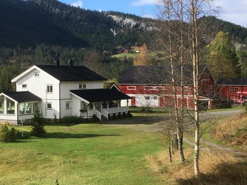 um grupo de edifícios num campo com uma árvore em Lie Hytteutleige -Gjestegård - Thor Fine Art 3 hytte enheter em Åmdals Verk