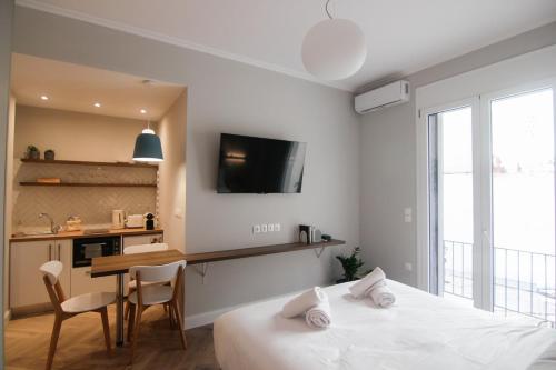 a room with two beds and a table and a tv at Patio Apartment near metro & Acropolis in Athens
