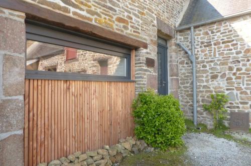 a wooden gate in front of a brick building at Maison d'hôtes KerCalow, Chambres d'hôtes in Pleine-Fougères
