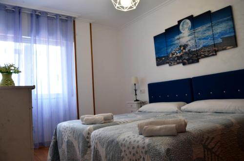1 dormitorio con 1 cama con 2 toallas en REGO DA RAÑA APARTMENTS, en Arzúa