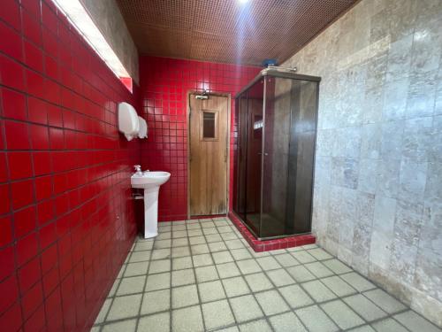 a red bathroom with a shower and a toilet at César Park Hotel in Juiz de Fora