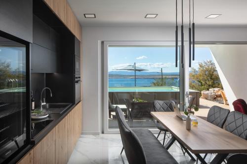 a kitchen and dining room with a table and chairs at Villa SPA DECK 1, DECK 2, DECK 3 in Dramalj