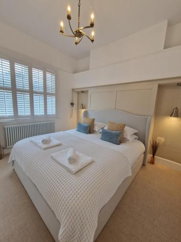 a bedroom with a large white bed with blue pillows at South Coast Beach Holiday Home-3 BED-GF-Sleeps 6-Free Parking-Walk to Beach-Private Garden- Families-Professional Groups-Contractors WELCOME in Bournemouth